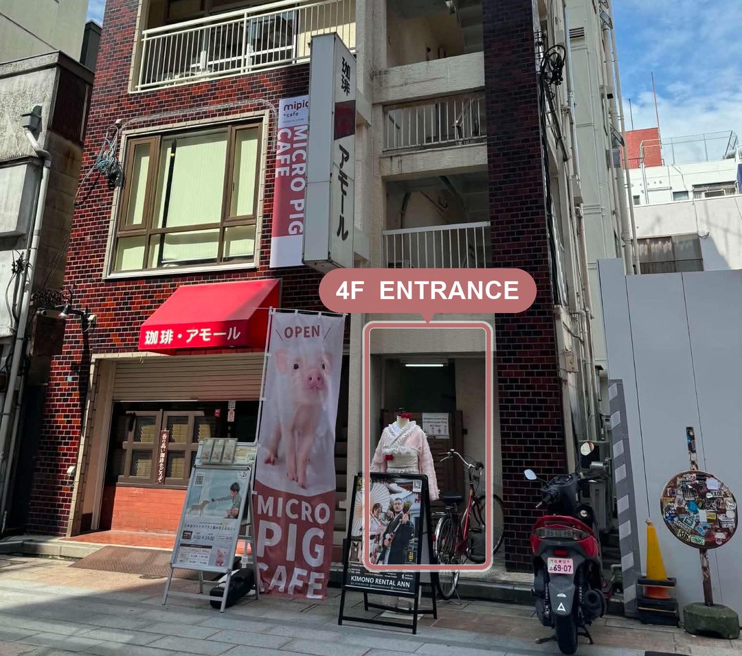 Our building: red 珈琲・アモール awning and MICRO PIG CAFE banner. The entrance is on the right; take the elevator to 4F.
